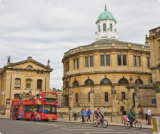 Red double-decker bus on Oxford street with Radcliffe Camera