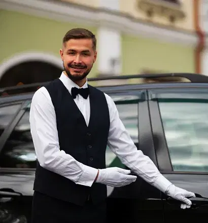 Professional chauffeur opening the door for a corporate client