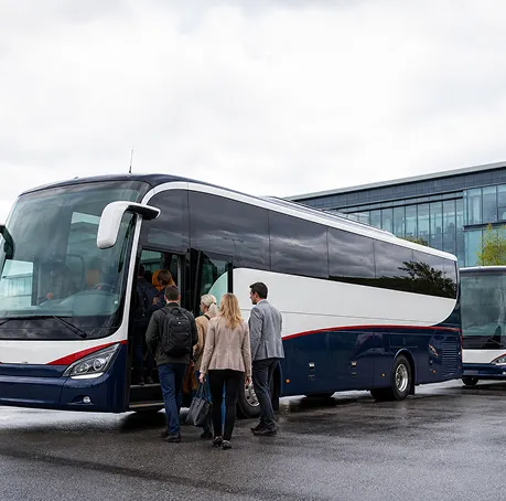 Corporate team boarding a minibus with driver for an away day